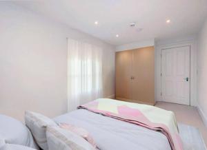 a white bedroom with a bed and a window at Deluxe 2 Bed by Buckingham Palace in London