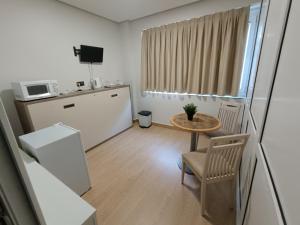 a small kitchen with a small table and a microwave at Habitaciones Javier LVI 0006 in Vitoria-Gasteiz