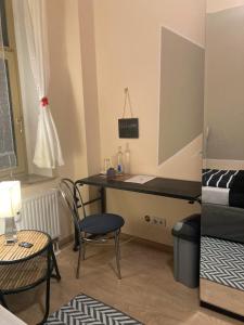 een kamer met een bureau, een bed en een stoel bij Adam's Pension in Chemnitz