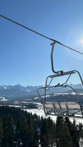 a ski lift chair with a view of a snow covered mountain at Ski House Czarna Góra in Czarna Góra