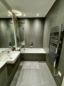 a bathroom with a tub and a sink and a mirror at Spacious 1 Bed Flat in London in London