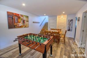 a foosball table in a living room with a dining room at Cottage Quebec - La Nepheline in Petite-Rivière-Saint-François
