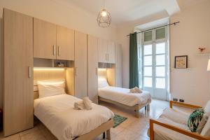 a bedroom with two beds and a window at La casa di Levi, in centro a Torino in Turin