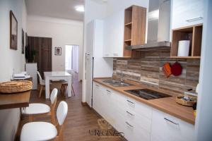 a kitchen with white cabinets and a table and chairs at La Regina Luxury Holiday Home in Cava deʼ Tirreni