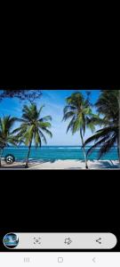 TV con una foto de una playa con palmeras en SEBULENI LUXURY HOMESTAY - WALK TO NYALI BEACH Mombasa, en Mombasa