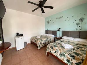 a bedroom with two beds and a ceiling fan at Hotel Marcianito in Isla Mujeres