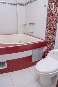 a bathroom with a toilet and a bath tub and a toilet at Hotel Las Canastas in Jaén