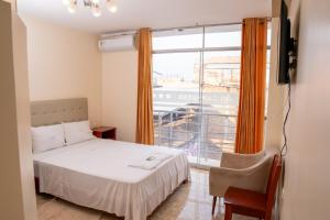 a bedroom with a bed and a large window at Hotel Las Canastas in Jaén