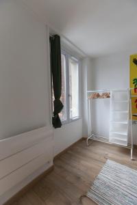 um quarto com uma parede branca e uma janela em Pleasant studio in hypercenter em Saint-Denis
