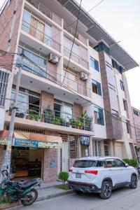 um carro branco estacionado em frente a um edifício em Hotel Las Canastas em Jaén