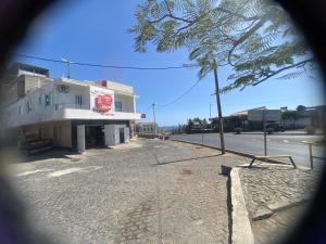 una calle vacía con un edificio al lado de una carretera en Infinito House 24 en Praia