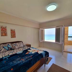 a bedroom with a bed with a view of the ocean at Hotel appartment sea view 3 bedrooms 3 toilets 4th floor Bellevue village agami alexandria families are preferred available all year days & 5 blankets available in Alexandria