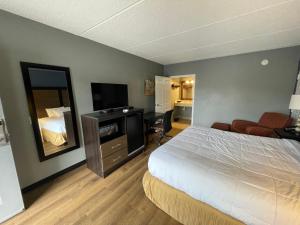 een hotelkamer met een bed en een televisie bij Econo Lodge in Forest City