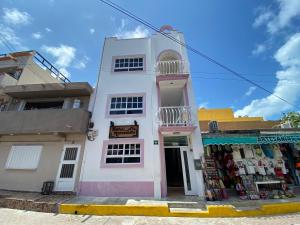 a white and pink building with a store at Hotel Marcianito in Isla Mujeres
