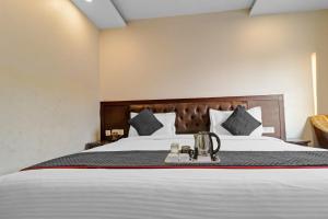 a bedroom with a large bed with white sheets and pillows at Galaxyy The Hotel Near Delhi Airport in New Delhi