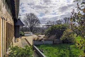 una casa con un patio con plantas y un edificio en Norman house with jacuzzi en Touques