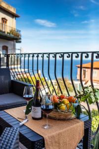 a table with two glasses of wine and a basket of fruit at SUITE APARTMENT TAORMINA in Taormina