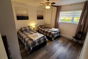 een hotelkamer met 2 bedden en een raam bij Cottage Quebec - Olivine in Petite-Rivière-Saint-François