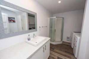 a white bathroom with a sink and a shower at Cottage Quebec - Olivine in Petite-Rivière-Saint-François