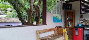a room with a bench and a red refrigerator at Casa da árvore na praia in São Sebastião