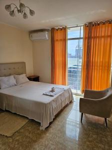 una camera con un letto e una sedia e una finestra di Hotel Las Canastas a Jaén