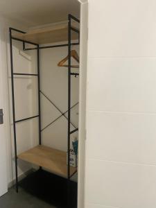 a walk in closet with a black shelving unit at Chambre privée Sdb kitchenette proche de Paris in Saint-Ouen