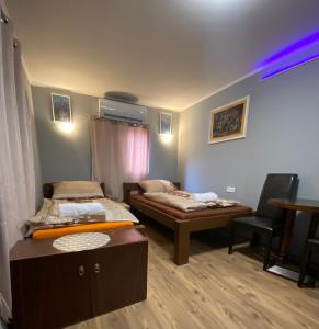 Cette chambre comprend 2 lits et un bureau. dans l'établissement Babér Apartmanház Balatonakarattya, à Balatonkenese