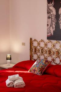 a red bed with a pillow and towels on it at SUITE APARTMENT TAORMINA in Taormina