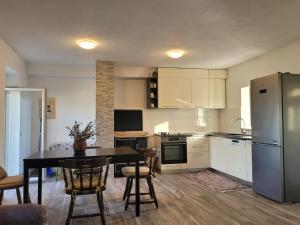 a kitchen with a table and a refrigerator at Mara village house in Vrlika