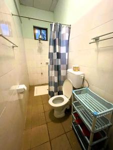 a bathroom with a toilet and a shower at Home Feeling Neneu Lodge in Moshi
