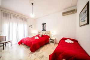 two beds in a room with red sheets at SUITE APARTMENT TAORMINA in Taormina
