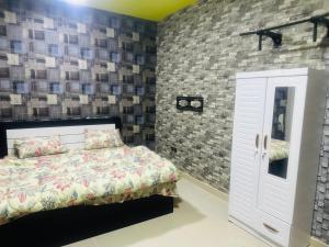 a bedroom with a bed and a brick wall at Modern Comfort Fully Furnished Room for Rent in Ajman 