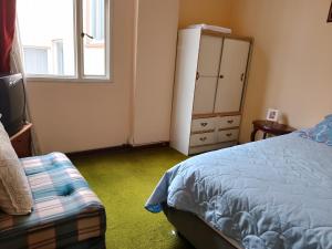 1 dormitorio con 1 cama, vestidor y ventana en Alojate y Descansa, en Bogotá