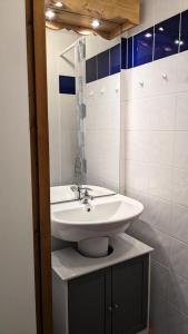 a bathroom with a white sink and a mirror at Résidence BALCONS DU SOLEIL - 3 Pièces pour 6 Personnes 404 in Orcières