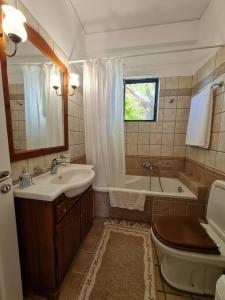 y baño con lavabo, aseo y bañera. en Filiatra Cosy House en Filiatra