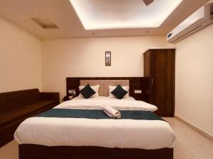 a bedroom with a large bed and a couch at The Ganga Breeze Haridwar in Haridwār