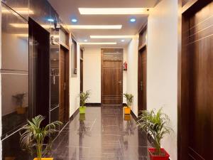 un couloir avec des plantes en pot dans un bâtiment dans l'établissement The Ganga Breeze Haridwar, à Haridwar