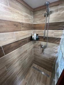 La salle de bains est pourvue d'une douche et de carrelage en bois. dans l'établissement Chata v Bučinách, à Turnov