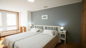 1 dormitorio con 2 camas y ventana en Apartamento de Castro 2º IZ, en Ponteceso