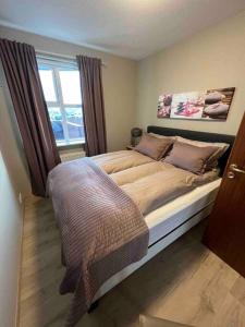 - une chambre avec un grand lit et une fenêtre dans l'établissement Asa´s comfortable, cozy nest in the north., à Akureyri