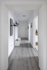 an empty hallway with white walls and wood floors at Biebrach's Ferienwohnungen in Wilhelmshaven