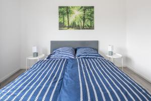 a bedroom with a bed with blue and white stripes at Biebrach's Ferienwohnungen in Wilhelmshaven