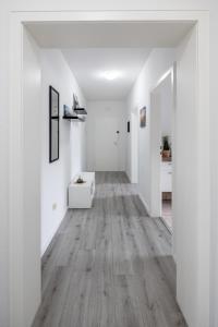 un pasillo vacío con paredes blancas y suelo de madera en Biebrach's Ferienwohnungen, en Wilhelmshaven