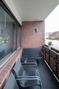 a balcony with benches and a brick wall at Biebrach's Ferienwohnungen in Wilhelmshaven