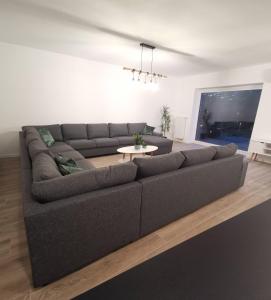 Sala de estar con sofá gris y mesa en Ten Velde, en Hoeselt