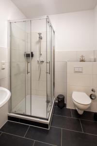 a bathroom with a glass shower and a toilet at Biebrach's Ferienwohnungen in Wilhelmshaven