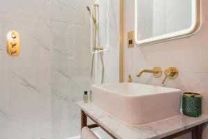y baño blanco con lavabo y ducha. en Chris Wheeler at The Crown Inn en Buckinghamshire