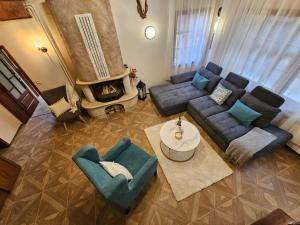 a living room with a couch and chairs and a fireplace at Вила Пенчеви, кк. Цигов чарк in Tsigov Chark