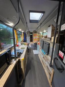 une vue intérieure d'un bus avec des tables et des comptoirs dans l'établissement TERMINUSBUS, à Crèvecoeur-le-Grand