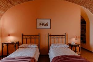 twee bedden in een kamer met twee lampen op tafels bij Sky & Vineyards - Melograno - in La Morra